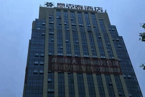 A tall building with a large sign on the side. - Leiketai Theme Hotel (Bengbu Railway Station Branch) (Bengbu)