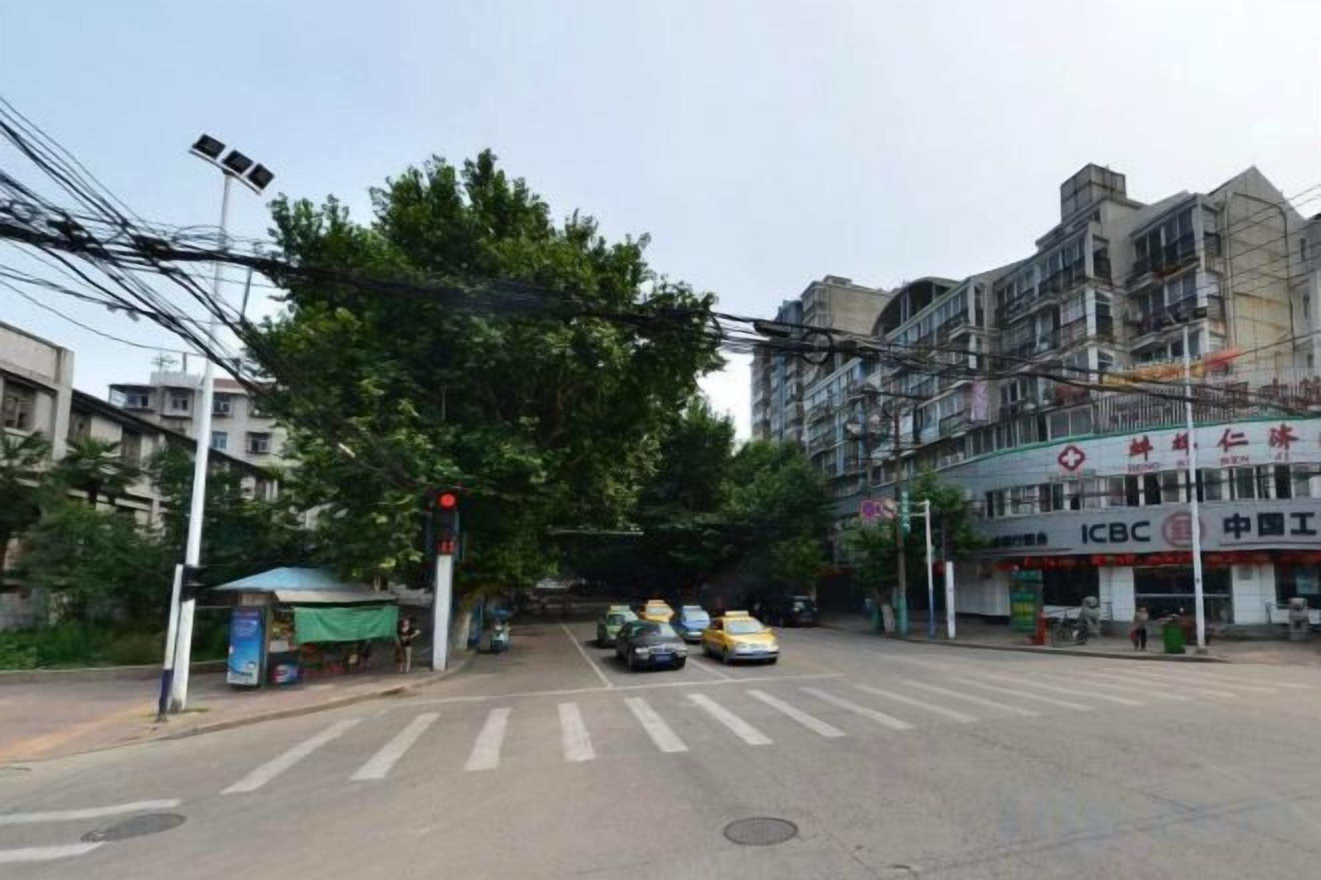 A street intersection with a traffic light, a crosswalk, and a building with signage.