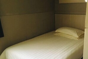A single bed with a headboard and a pillow in a room with plain walls. - Jinjiang Inn (Shanghai Maotai Road) (Shanghai)