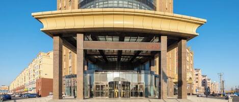 A building with a curved entrance, a glass facade, and a central atrium.