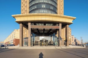 Ein Gebäude mit einem gewundenen Eingang, einer Glasfassade und einem zentralen Atrium.