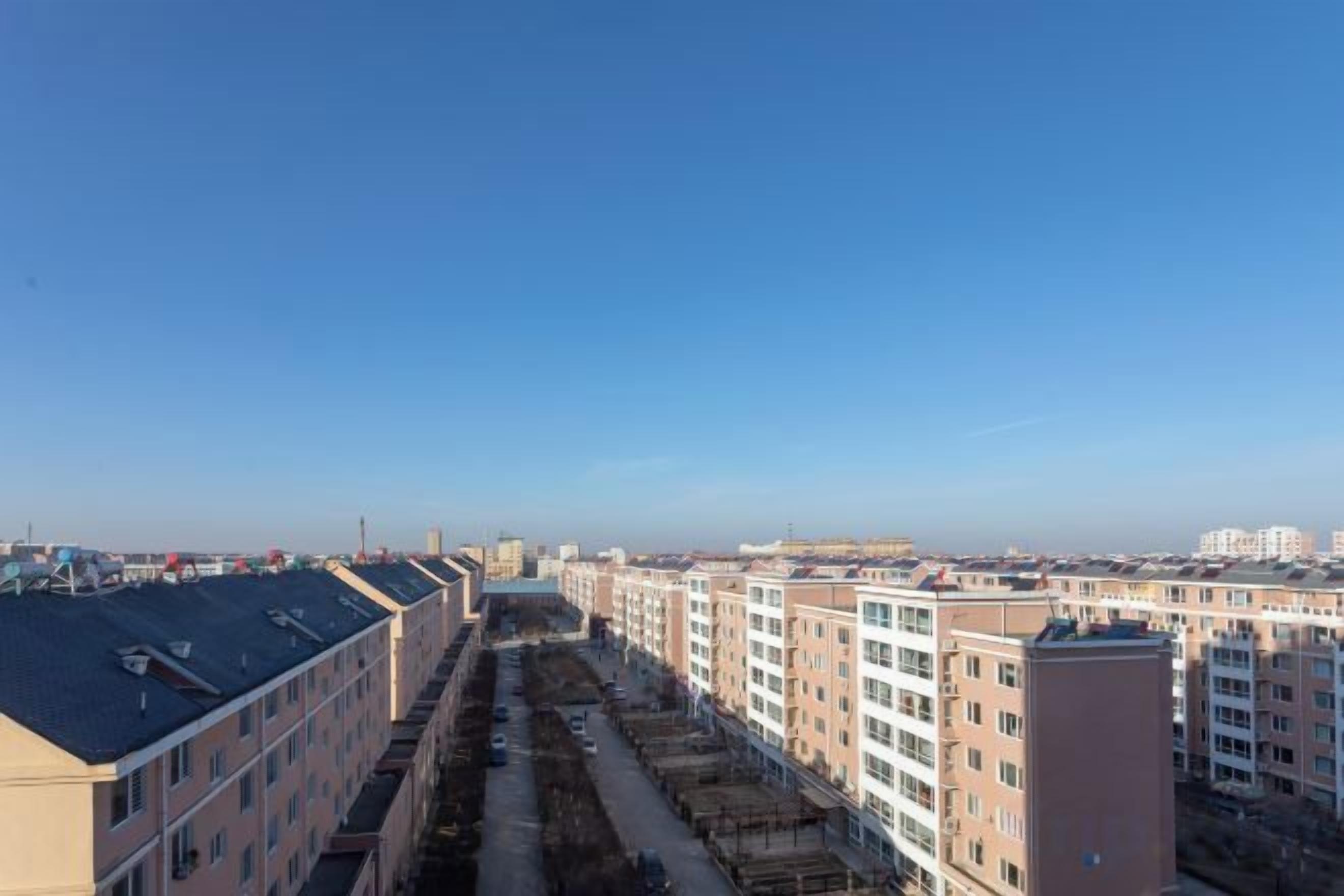 Una hilera de edificios de varios pisos bajo un cielo despejado.