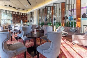 A hotel lobby with seating areas, a reception desk, and decorative elements. - Panshan Yinlong Hotel (Panshan)