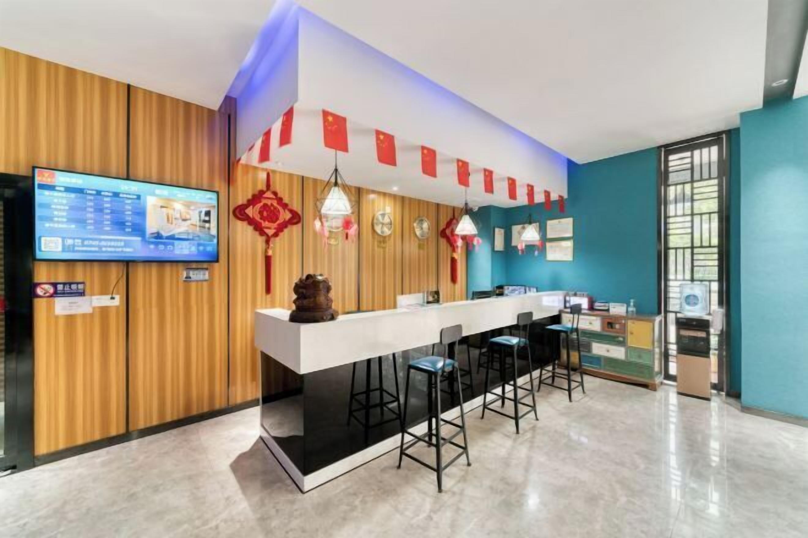 A modern hotel lobby with a reception desk, bar area, and seating.