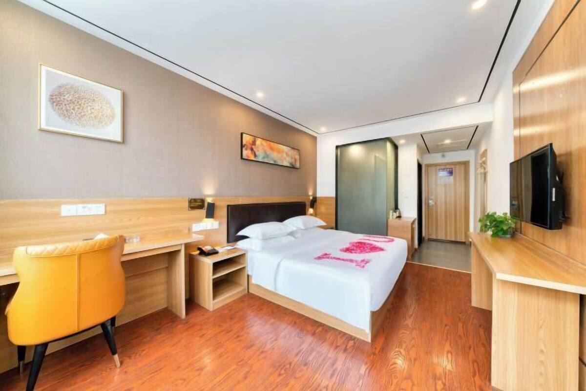 Una habitación de hotel moderna con cama, escritorio y televisor.
