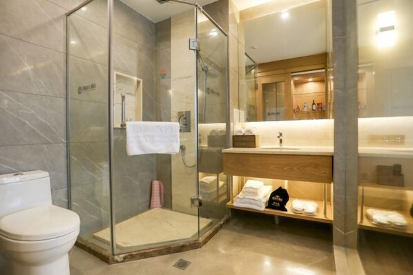 A modern bathroom with a glass-enclosed shower, a white toilet, and a vanity with a mirror and shelves. - Diannan Hotel (Tonghai)