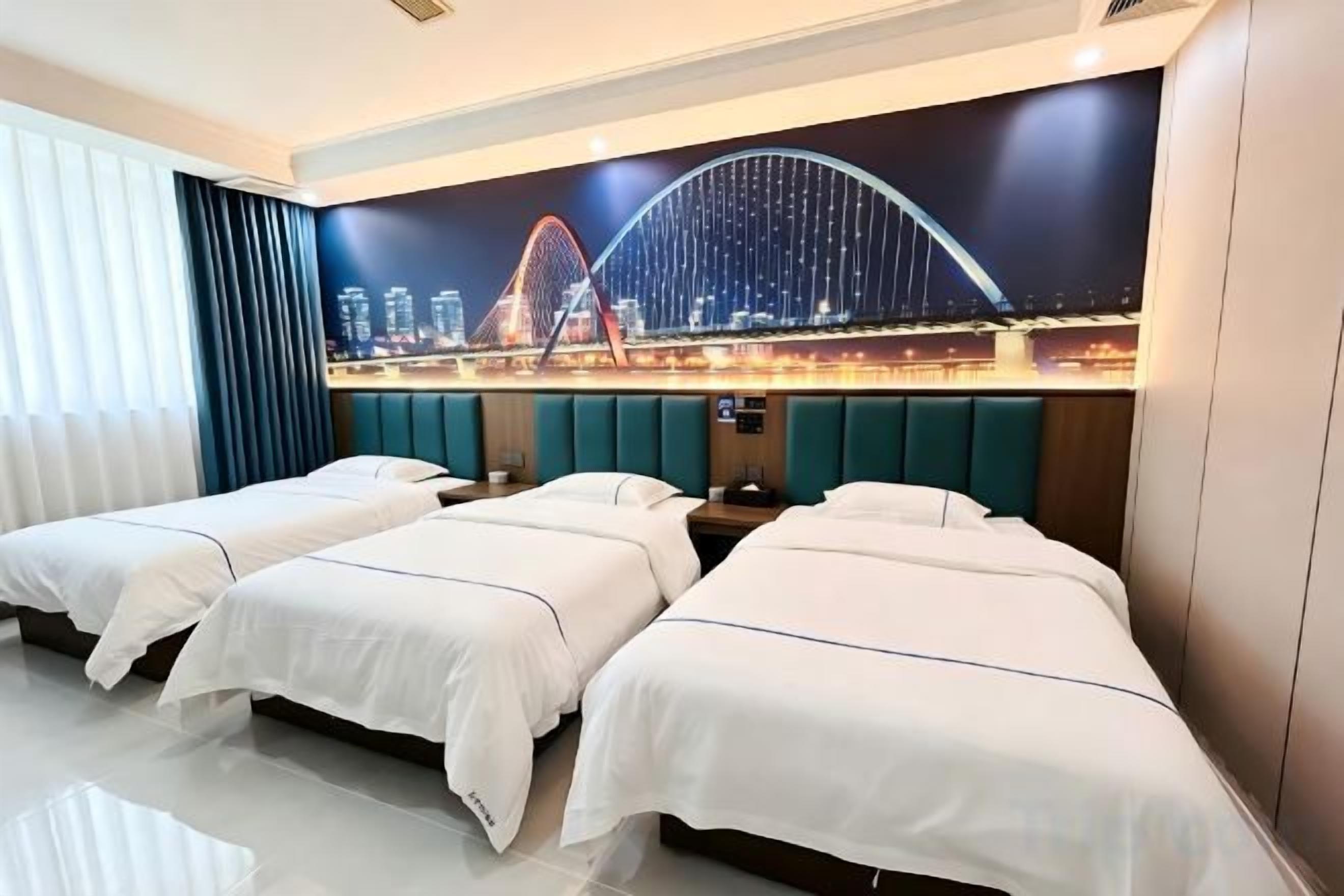 Habitación de hotel con tres camas, un mural de paisaje urbano y un diseño moderno.