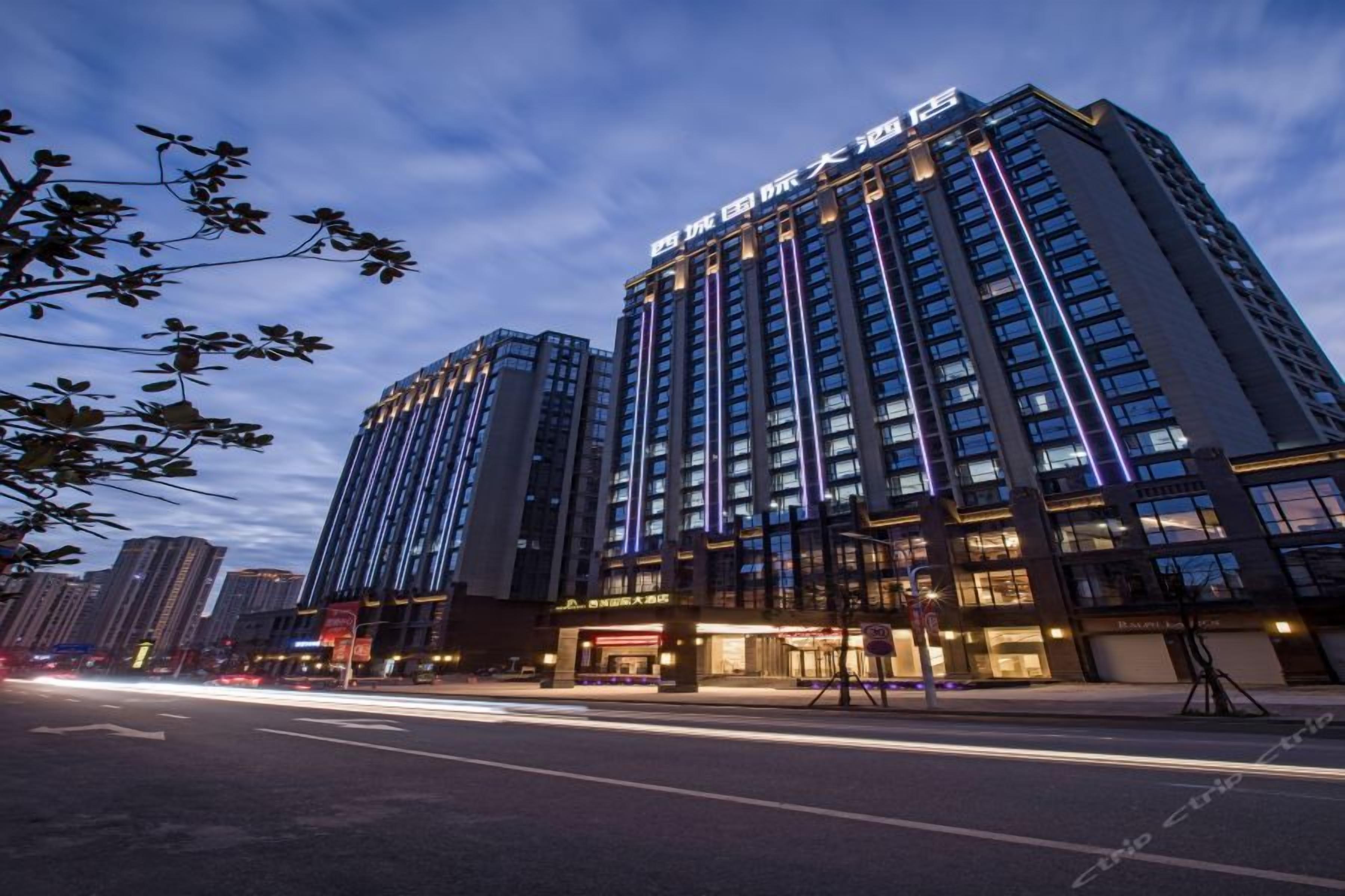 A high-rise hotel with multiple floors, large windows, and illuminated signage.