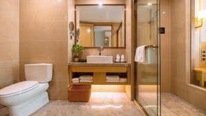 Une salle de bain moderne équipée de toilettes, d’un lavabo et d’une douche à parois de verre.