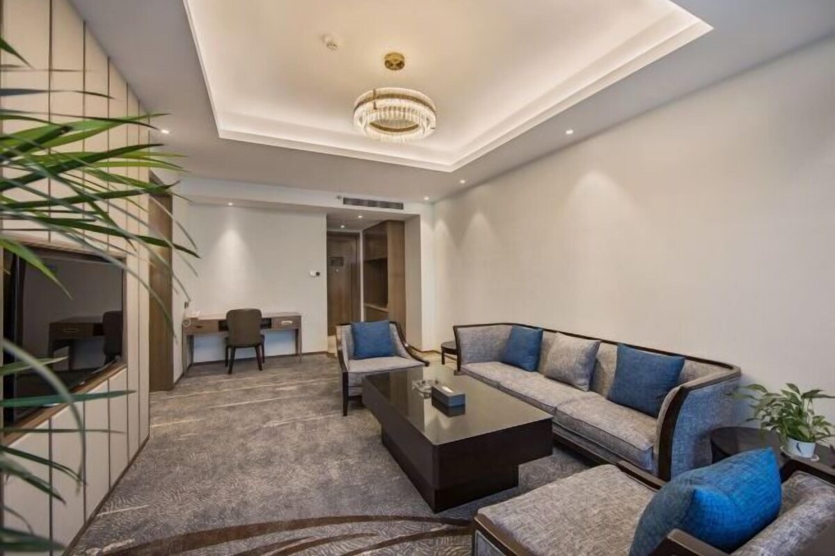 Un salon moderne comprenant un canapé, des fauteuils, une table basse et un bureau.