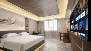 A modern hotel room with a large bed, a desk, and a wall-mounted TV.