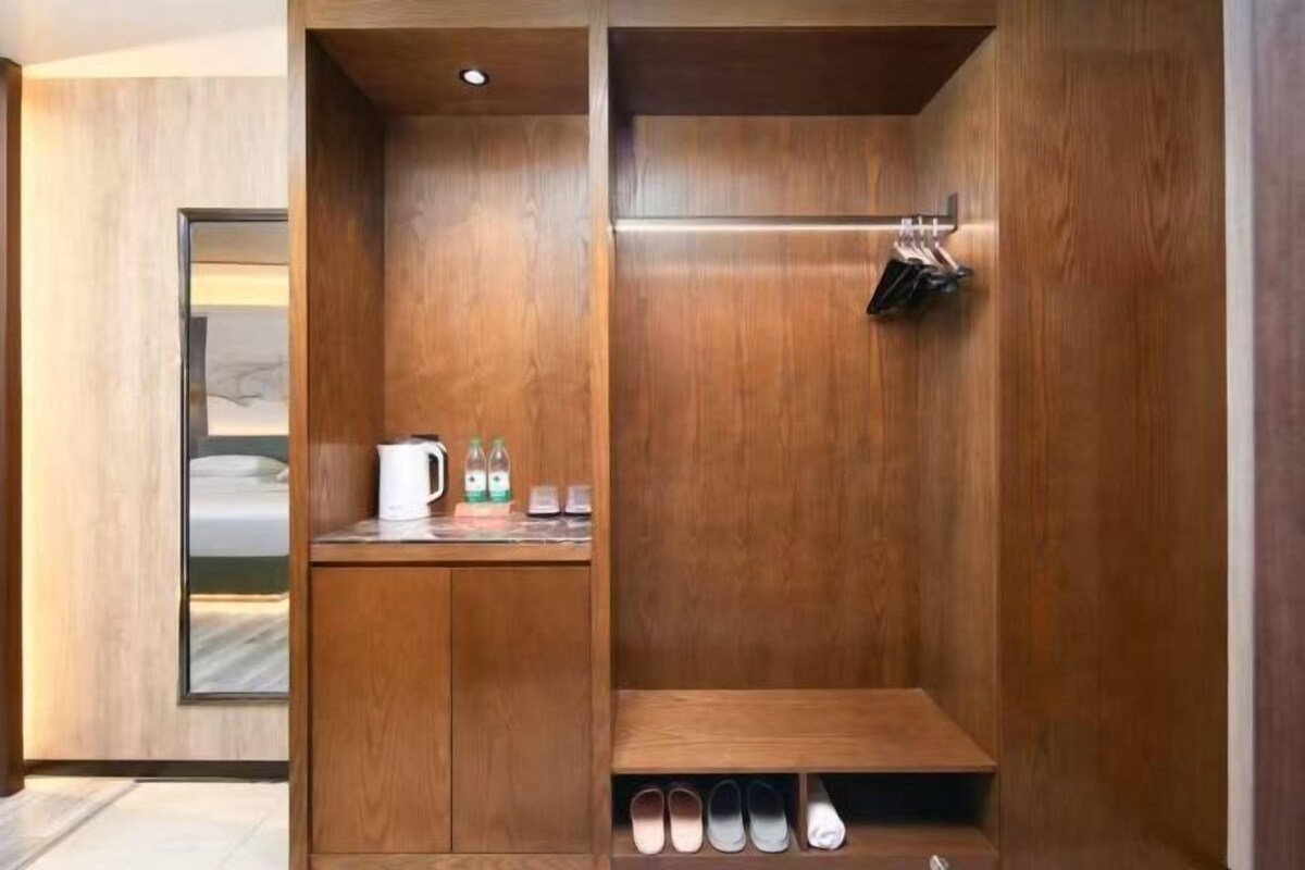 Un baño moderno con muebles de madera, lavamanos integrado y un zapatero.