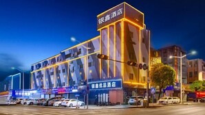 Un hotel moderno con un cartello ben visibile, un parcheggio e vista sulla strada.