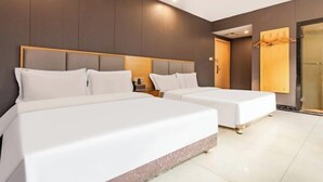 Camera d'albergo con due letti, una testiera e una porta in legno, e un appendiabiti.