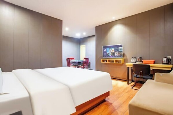 Una habitación de hotel con cama, escritorio, silla y televisor.