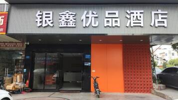 A hotel entrance with a sign reading '银鑫优品酒店'.