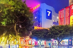 A building with a prominent number 7 sign, surrounded by trees and illuminated by colorful lights. - 7 Days Inn (Rongchang Commercial Pedestrian Street) (Chongqing)