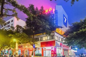 A hotel with a prominent '7' sign, a visible entrance, and a storefront with signage. - 7 Days Inn (Rongchang Commercial Pedestrian Street) (Chongqing)
