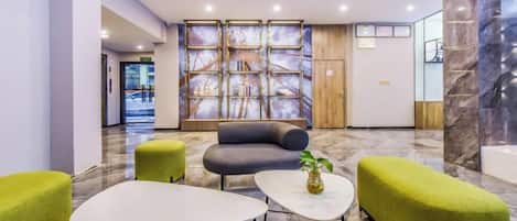 A lobby with seating, a reception desk, and a wall with a patterned design.