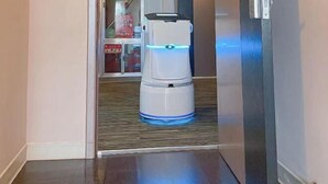 A robot with a blue light on a polished floor in a hallway. - Jinjiang Inn Style (Huaxi District Xiahe Vanke Metropolis Store GuiyangGuizhou) (Guiyang)