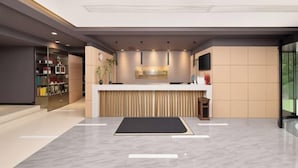 A modern reception area with a reception desk, a plant, and a counter with a television. - Jinjiang Inn Style (Huaxi District Xiahe Vanke Metropolis Store GuiyangGuizhou) (Guiyang)