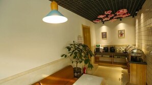 A modern kitchen with a wooden bench, a potted plant, and a ceiling with a grid pattern.