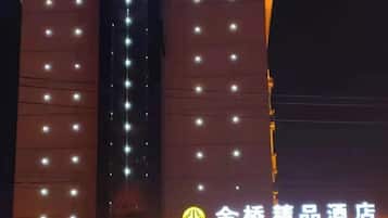 A building facade with evenly spaced lights and a sign with Chinese characters.