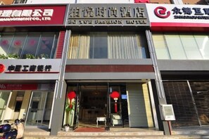 A hotel with a visible entrance, a reception desk, and a closed shutter to the right.
