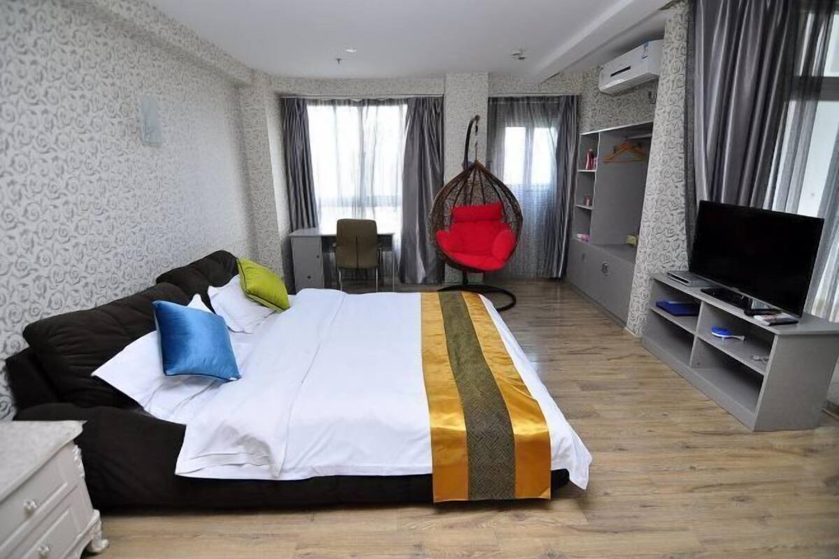 Une chambre d’hôtel avec un lit, une télévision, un bureau et une chaise.