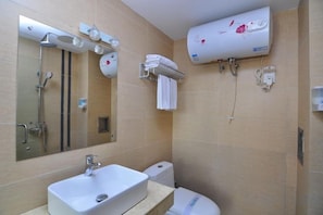 A bathroom with a sink, mirror, shower, and toilet.