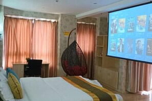 A hotel room with a bed, a desk, a hanging chair, a television, and curtains. - Baiyue Fashion Hotel (Yuxi Dongfeng Square) (Yuxi)