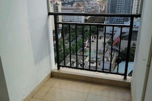 Un balcón con barandilla metálica que da a una vista panorámica de la ciudad.