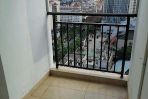 A balcony with a metal railing overlooking a cityscape.