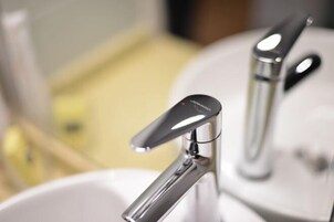 Un baño con un grifo y lavamanos modernos.