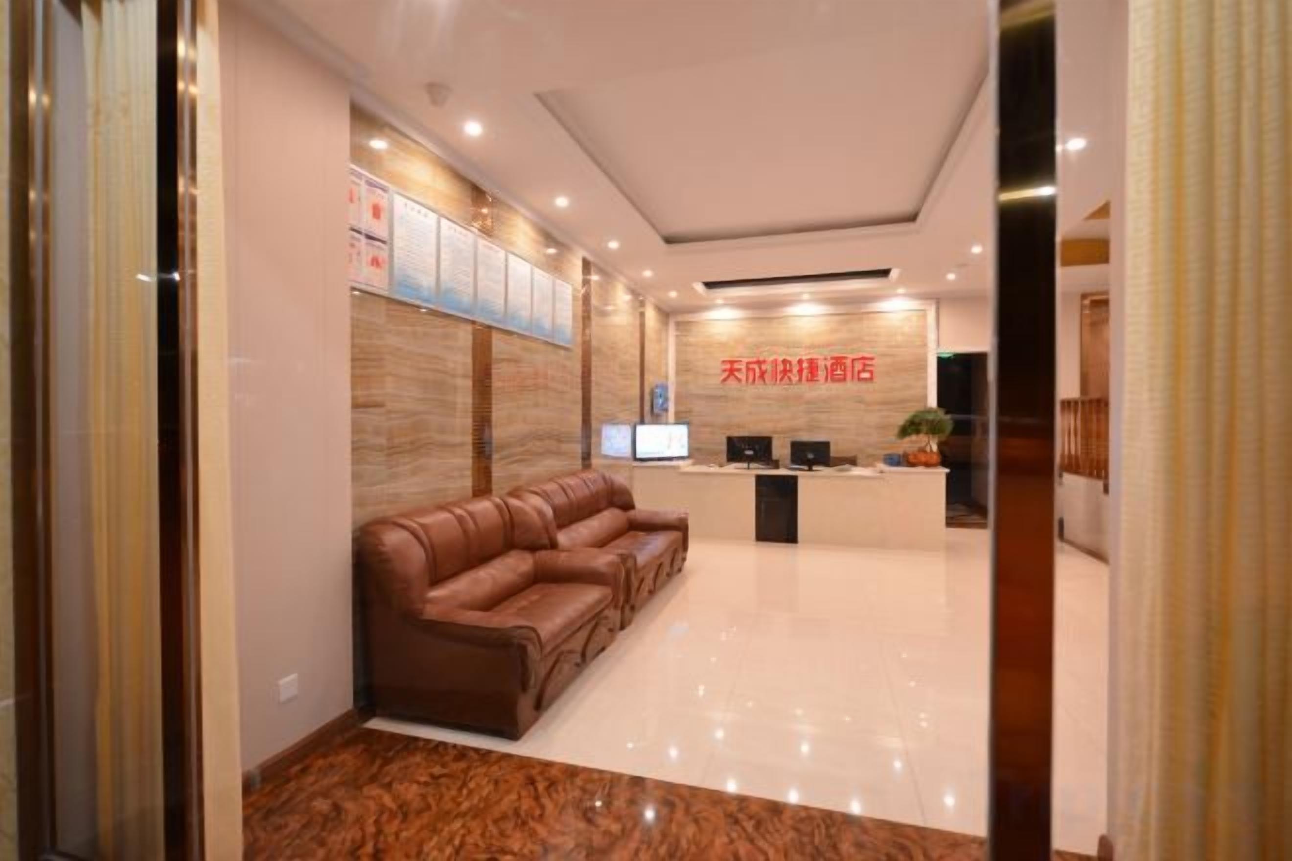 A reception area with a sofa, a reception desk, and a wall-mounted TV.