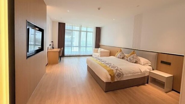 A modern hotel room with a large bed, bedside tables, a desk, and a large window. - Sumahui Hotel (Suzhou East Railway Station Kechuang Center) (Suzhou)