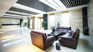 A modern lobby with a reception desk, leather seating area, and large windows. - Sumahui Hotel (Suzhou East Railway Station Kechuang Center) (Suzhou)