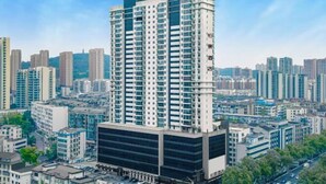 Un edificio de gran altura con diseño moderno, que destaca por una estructura cilíndrica en su parte superior.