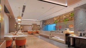 Un moderno vestíbulo de hotel con mostrador de recepción, zona de estar y mostrador de cocina.