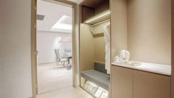 Un baño moderno con tocador, perchero y cafetera sobre la encimera.