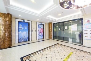A hotel lobby with a polished floor, a reception desk, and two elevators. - Shiman Art Hotel (Guangzhou Chebei Subway Station) (Guangzhou)