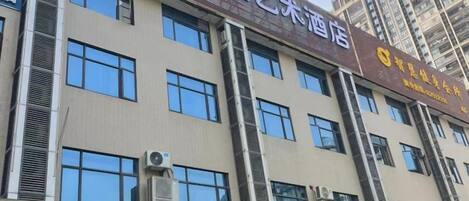 A multi-story building with signage for a hotel and various businesses.