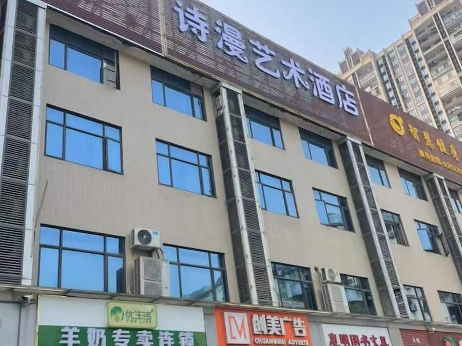 Un edificio de varios pisos con letreros que indican un hotel y varios comercios.