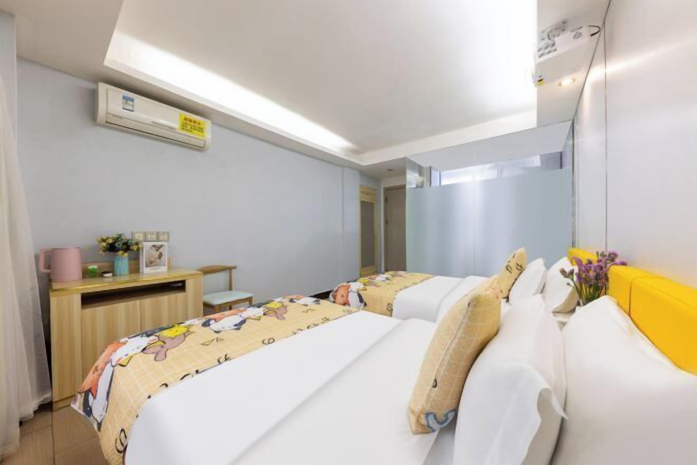 Hotellihuone, jossa on sänky, työpöytä, ilmastointilaite ja peili.