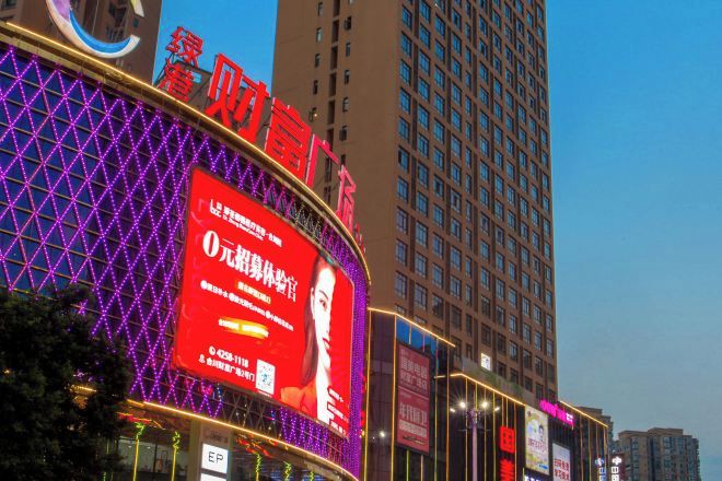 A building with a large digital billboard and illuminated signage.