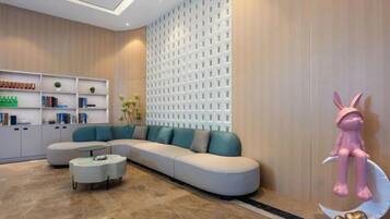 A modern living room with a sectional sofa, a coffee table, and a decorative wall with a lattice pattern.