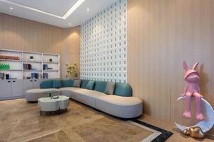 Una sala de estar moderna con un sofá modular, una mesa de centro y una pared decorativa con diseño de celosía.