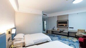 A hotel room with two beds, a desk, a mirror, and a small seating area. - Railway Grand Hotel (Xiangyang)