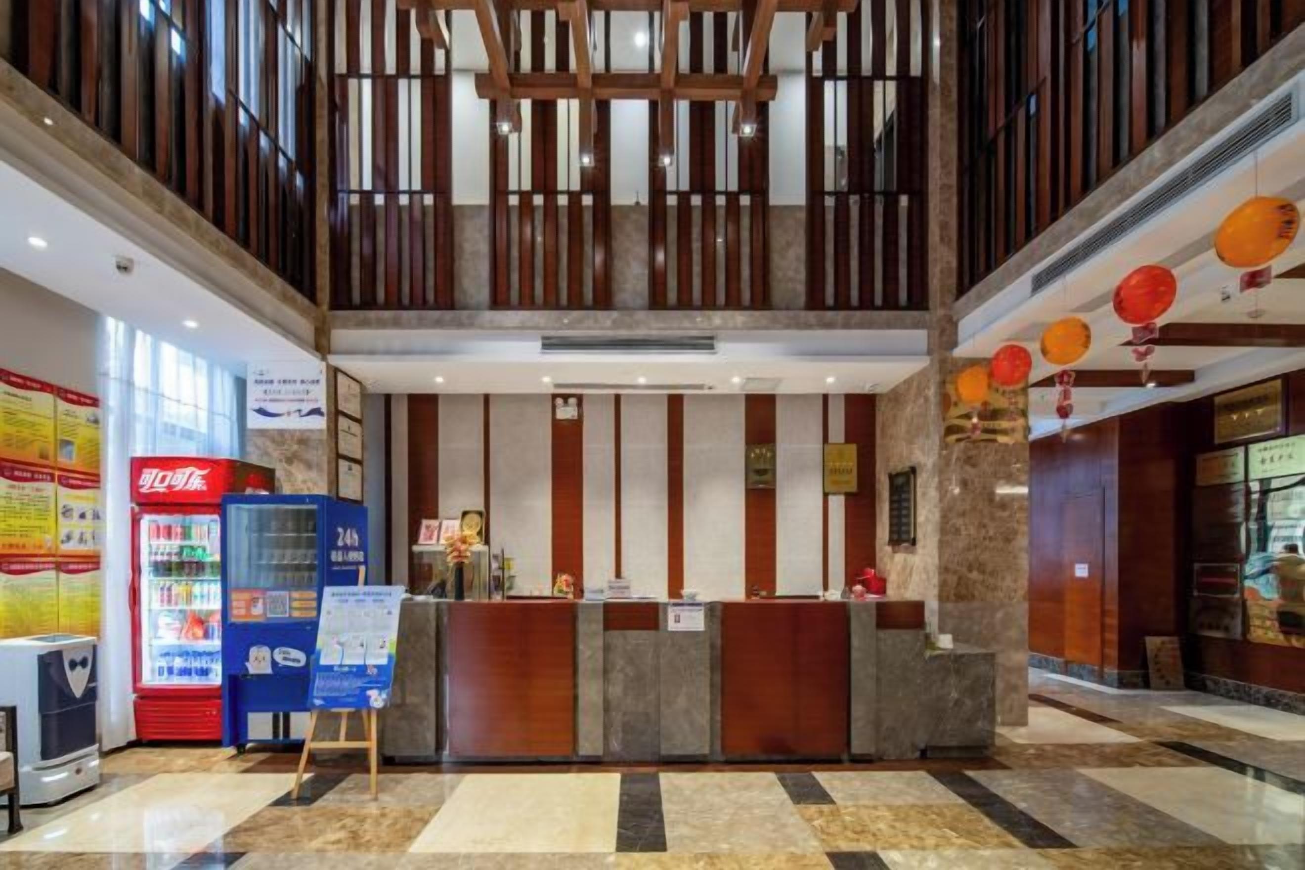 A hotel reception area with a counter, vending machines, and a bulletin board.