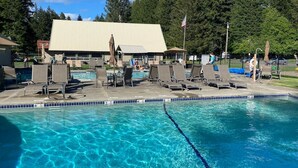 Une piscine avec des chaises longues et un espace abrité.